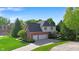 Rear exterior view of home with three-car garage, lush lawn and basketball hoop at 10390 Tremont Dr, Fishers, IN 46037