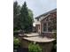 View of the home's rear exterior, featuring a brick and clapboard facade and a spacious patio at 10390 Tremont Dr, Fishers, IN 46037