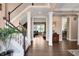 Inviting foyer featuring hardwood floors, white staircase, and views into living spaces at 10390 Tremont Dr, Fishers, IN 46037