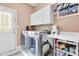 Well-equipped laundry room with washer, dryer, ample storage, and convenient folding area at 10390 Tremont Dr, Fishers, IN 46037