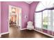 Pink sitting room featuring a large arched window, hardwood floors, and stylish decor at 10390 Tremont Dr, Fishers, IN 46037