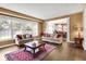 Bright living room featuring hardwood floors, large windows, and view into the kitchen at 10390 Tremont Dr, Fishers, IN 46037
