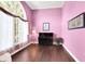 Pink room with hardwood floors, large arch window, baby grand piano, and recessed lights at 10390 Tremont Dr, Fishers, IN 46037