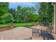 Picturesque brick patio area with outdoor seating and views of the beautifully landscaped backyard and mature trees at 10390 Tremont Dr, Fishers, IN 46037
