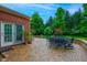Brick patio with outdoor seating and dining, adjacent to a lush green lawn, offering a serene and inviting outdoor space at 10390 Tremont Dr, Fishers, IN 46037