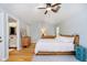 Bright bedroom with light gray walls, hardwood floors, ceiling fan and ensuite bath at 1045 Millwood Ct, Indianapolis, IN 46260