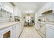 Clean white kitchen with modern appliances, tile flooring, and a cozy breakfast nook at 1045 Millwood Ct, Indianapolis, IN 46260
