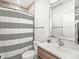 Bright bathroom with stylish mirror, modern fixtures, and a shower with striped curtain at 1048 St Peter St, Indianapolis, IN 46203