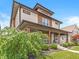 A charming two-story home boasts a covered front porch, landscaped yard, and unique architectural details at 1048 St Peter St, Indianapolis, IN 46203