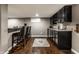 Basement bar area complete with bar seating and black cabinets for storage at 11674 Timken Ct, Fishers, IN 46037