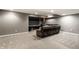 Finished basement with large screen television, leather furniture and neutral carpet at 11674 Timken Ct, Fishers, IN 46037