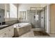 Well-lit bathroom with a soaking tub, walk-in shower, dual vanity, and neutral tile at 11674 Timken Ct, Fishers, IN 46037