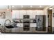 Granite countertops and stainless steel appliances in this modern kitchen area with pendant lighting at 11674 Timken Ct, Fishers, IN 46037