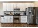 Well-lit kitchen featuring stainless steel appliances, white cabinetry, and dark granite countertops at 11674 Timken Ct, Fishers, IN 46037