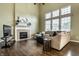 Bright living room with a fireplace, hardwood floors, large windows, and high ceilings at 11674 Timken Ct, Fishers, IN 46037