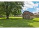 Backyard featuring large, green lawn with shed and mature tree at 11733 East 21St St, Indianapolis, IN 46229
