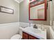 Cozy half-bathroom featuring a decorative mirror, wooden vanity, and white beadboard accents at 11733 East 21St St, Indianapolis, IN 46229