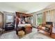 Spacious bedroom with a unique four-poster bed, a sitting area, and bright natural light at 11733 East 21St St, Indianapolis, IN 46229