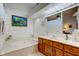Well-lit bathroom features a large soaking tub, complemented by a modern vanity and artwork at 12258 Charing Cross Rd, Carmel, IN 46033