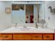Bathroom vanity featuring wood cabinets, a sleek countertop, a decorative mirror, and ample storage at 12258 Charing Cross Rd, Carmel, IN 46033
