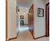 Hallway with neutral walls, wood trim, and closet doors, providing a glimpse into the home's layout at 12258 Charing Cross Rd, Carmel, IN 46033