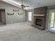 Bright living room with a skylight, ceiling fan, brick fireplace, and neutral carpeting at 12301 Winding Creek Cir, Indianapolis, IN 46236