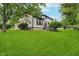 Spacious backyard with lush green lawn, mature trees and view of the house at 12563 Sandstone Run, Carmel, IN 46033