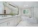 A luxurious primary bathroom with double vanity, marble countertops, soaking tub, and ample lighting at 12563 Sandstone Run, Carmel, IN 46033