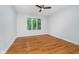 Bright bedroom with hardwood floors, a ceiling fan, and a large window at 12563 Sandstone Run, Carmel, IN 46033