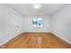 Bright bedroom with hardwood floors, a large window, and a double-door closet at 12563 Sandstone Run, Carmel, IN 46033