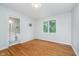 A minimalist bedroom featuring hardwood floors, natural light, and an ensuite bathroom at 12563 Sandstone Run, Carmel, IN 46033
