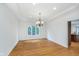 Spacious dining area featuring hardwood floors, chandelier lighting, and large windows at 12563 Sandstone Run, Carmel, IN 46033
