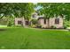 Beautiful brick home featuring a lush green lawn and mature trees providing shade at 12563 Sandstone Run, Carmel, IN 46033