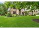 Charming brick home boasts a well-manicured lawn and picturesque landscaping at 12563 Sandstone Run, Carmel, IN 46033