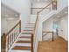 Bright foyer features hardwood floors and a classic staircase with white and wood banisters at 12563 Sandstone Run, Carmel, IN 46033