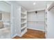 A walk-in closet with custom shelving provides storage space and leads to a luxurious bathroom at 12563 Sandstone Run, Carmel, IN 46033
