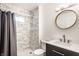 Modern bathroom featuring a marble-tiled shower, sleek vanity with a round mirror, and contemporary fixtures at 1342 N Oakland Ave, Indianapolis, IN 46201