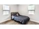 This cozy bedroom features two bright windows and stylish bed with gray bedding on wood laminate flooring at 1342 N Oakland Ave, Indianapolis, IN 46201