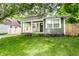 Charming bungalow with inviting covered porch and a lush green lawn at 1342 N Oakland Ave, Indianapolis, IN 46201