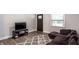 Cozy living room showcasing a plush sofa, modern TV console, decorative rug, and natural light from the window at 1342 N Oakland Ave, Indianapolis, IN 46201