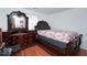 Cozy bedroom featuring hardwood floors, a decorative dresser with mirror, and a comfortable bed at 1363 Briar Meadow Ct, Indianapolis, IN 46217