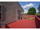 Exterior angle showing a red wooden deck attached to the house with access to an enclosed sunroom at 1363 Briar Meadow Ct, Indianapolis, IN 46217
