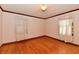Spacious bedroom featuring hardwood floors and natural light from two windows with white curtains at 1440 Brandt Dr, Indianapolis, IN 46241