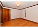 Cozy bedroom with hardwood floors, a wood door and a window dressed with sheer curtains at 1440 Brandt Dr, Indianapolis, IN 46241