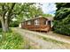 Inviting brick house with a wooden ramp, surrounded by lush greenery and mature trees at 1440 Brandt Dr, Indianapolis, IN 46241