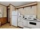 Practical kitchen with white appliances, wood paneling and wallpaper at 1440 Brandt Dr, Indianapolis, IN 46241