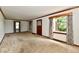 The carpeted living room with wood trim and large windows for ample light at 1440 Brandt Dr, Indianapolis, IN 46241