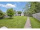 Large, grassy backyard with wooden fence and storage shed, perfect for outdoor activities at 1521 N Gladstone Ave, Indianapolis, IN 46201