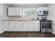 Kitchen with stainless appliances, white cabinets, tile backsplash and butcher block countertops at 1521 N Gladstone Ave, Indianapolis, IN 46201