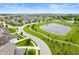 Aerial view showcasing the community's winding streets, lush greenery, and serene pond at 15580 Garrano Ln, Fishers, IN 46040
